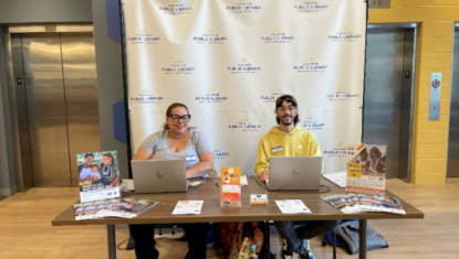 Two people sitting at a table with laptops